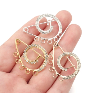 Detailed view of crystal zircon U-shaped safety pins in gold, silver, and rose gold