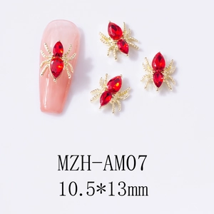 Detailed close-up of 10.5x13mm gold spider nail charms with red rhinestones