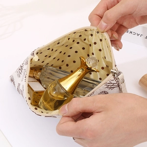 Detail view of canvas cosmetic bag interior, featuring polka dot lining and spacious storage.