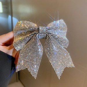 Macro shot of silver bow hair clip featuring shimmering rhinestones and 3D ribbon details
