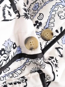 Close-up of quilted floral jacket with paisley print and tortoise shell buttons