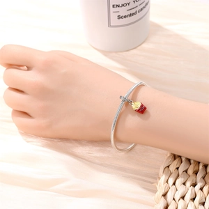 Silver snake chain bracelet featuring a red fries pendant with FRIES engraving on wrist