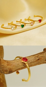 Detail of adjustable gold rings with heart-shaped zircon stones and hammered texture finish