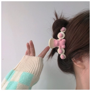 Close-up of cream hair claw clip with pink 3D hearts and a bear with Smile engraving