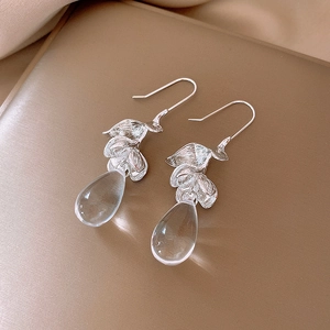 Silver leaf drop earrings with clear teardrop crystal on luxury gold satin fabric