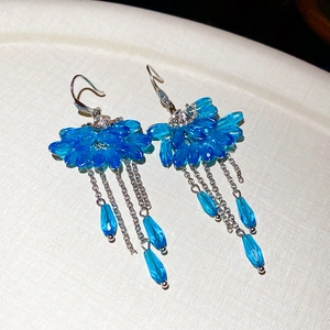 Macro shot of royal blue zircon fan-shaped pendant with elegant silver tassel drop earrings