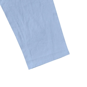 Detailed macro view of light blue linen fabric texture on trouser cuff or sleeve hem