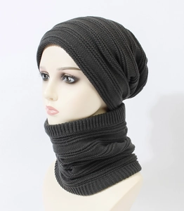 Close-up of dark grey winter knitted hat and scarf set with thick textured rib patterns