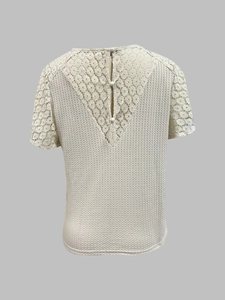 Detail der V-Ausschnitt-Spitze am Rücken mit Perlenknopf an einem cremefarbenen Stricktop