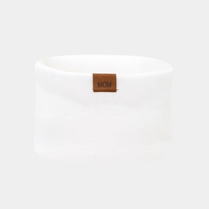 Close-up of white knitted neck warmer with a brown leather patch featuring MOM text