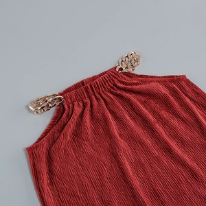 Detail of burgundy pleated halter top featuring decorative gold metal chain straps