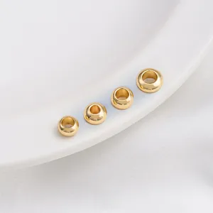 Macro shot of 14K gold filled spacer beads in four sizes on white ceramic plate