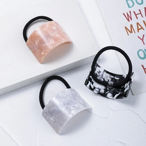 Three acetate hair ties with marble patterns including pink, grey, and black patterns