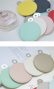 Detail of round leather vanity mirror pendants with metallic rings in diverse colors