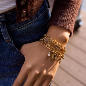 Mehrlagiges goldenes Edelstahl-Vogelarmband mit Wassertropfenanhänger am Handgelenk