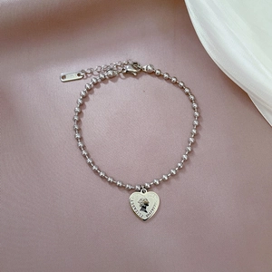 Detailed shot of silver steel bead bracelet with Queen heart coin pendant and lobster clasp