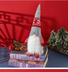 Close-up of a Nordic Christmas gnome doll sitting on vintage books with a red background