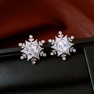 Macro shot of silver snowflake earrings with cubic zirconia on black leather display