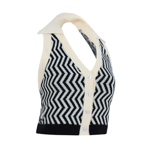Dettaglio del gilet in maglia chevron bianco e nero con colletto crema e bottoni bianchi