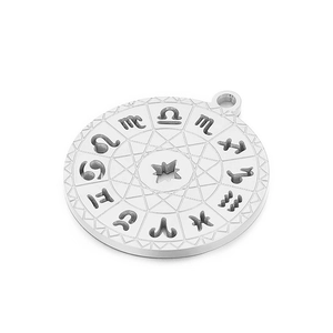 Detailed close-up of a silver zodiac pendant with embossed symbols and geometric texture
