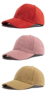 Close-up of three baseball caps in red, pink, and yellow with soft suede texture