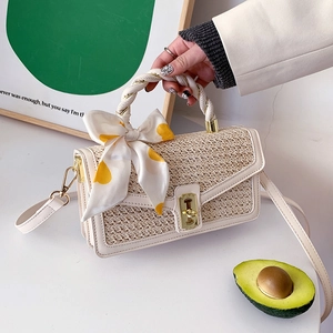 Beige straw woven handbag with yellow polka dot scarf and gold metal lock closure