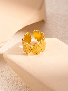 Macro shot of gold ginkgo leaf ring with detailed relief texture and adjustable open band