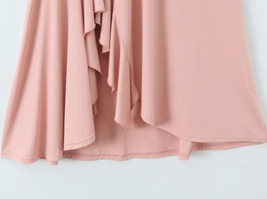 Détail de l'ourlet irrégulier rose montrant le tissu drapé et les coutures nettes
