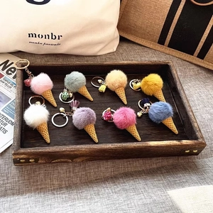 Collection of colorful plush ice cream keychains displayed on a rustic wooden tray