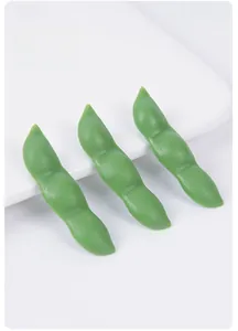 Macro detail of artificial green pea pods with realistic texture on a white background