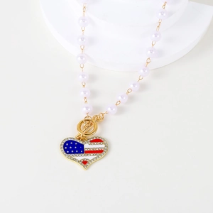 Macro view of heart-shaped USA flag pendant with rhinestones and pearl chain necklace