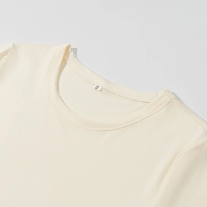 Dettaglio ravvicinato della scollatura in maglia color crema con texture in cotone e tag S