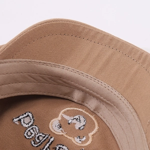 Close-up of khaki cotton hat featuring precise double-stitch seams and bear embroidery