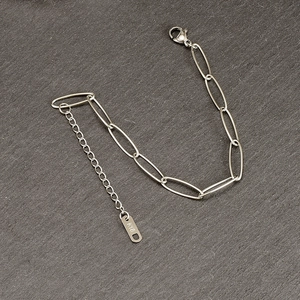 Detaillierte Makroansicht des 18K Gold Paperclip Armbands mit graviertem Anhänger