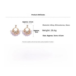 Detail of vintage gold earrings with green rhinestones and purple glass bead tassels