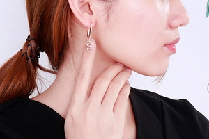 Close-up of rose gold chain-link earrings on female model for a minimalist style