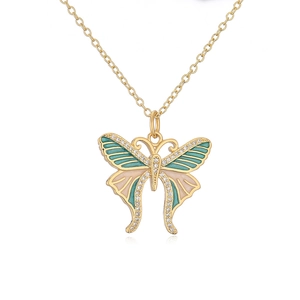 Macro detail of gold butterfly necklace with teal and pink enamel and zircon accents