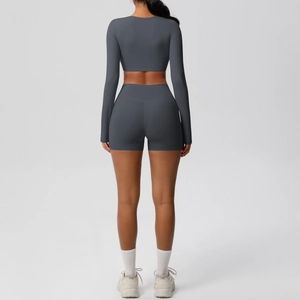 Rear view of two-piece dark grey athletic set featuring long sleeve crop top and biker shorts