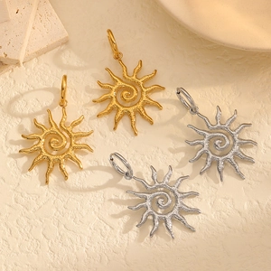 Macro detail of French vintage sun earrings with spiral texture and hammered metal finish