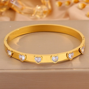 Gros plan sur le bracelet en acier doré avec zircons cubiques en forme de cœur incrustés