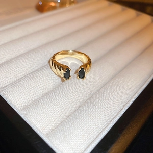 Macro detail of a gold plated dragon ring with black marquise zircon in a jewelry box