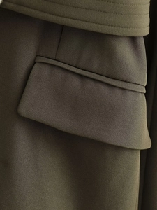 Gros plan du blazer vert olive en sergé avec rabat de poche et coutures détaillées de qualité