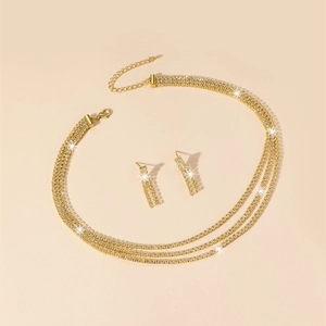 Detail view of a gold-tone bridal jewelry set featuring rhinestone necklace and earrings