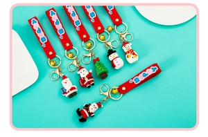 Detail of Christmas PVC keychains featuring Santa, Snowman and Tree with red wrist straps