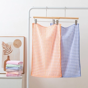 Absorbent cotton waffle tea towels in various colors hanging and stacked for display
