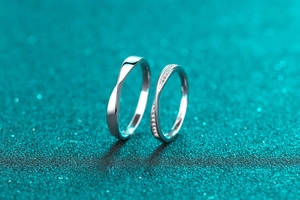 Close-up of S925 silver couple rings featuring a twisted band and pavé moissanite stones