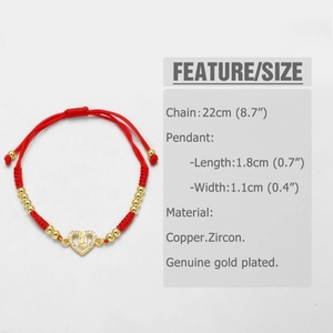 Detail of red braided cord bracelet with gold heart charm and Virgin Mary engraving