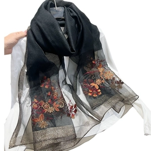 Elegant black embroidered scarf with red floral patterns and delicate gold trim