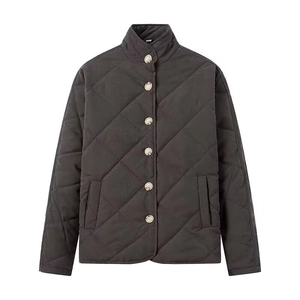 Detail of dark grey quilted jacket featuring diamond pattern texture and stand-up collar