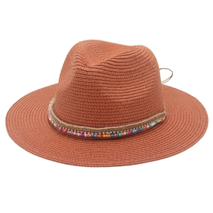 Detail of terracotta straw fedora with colorful beaded band and woven texture